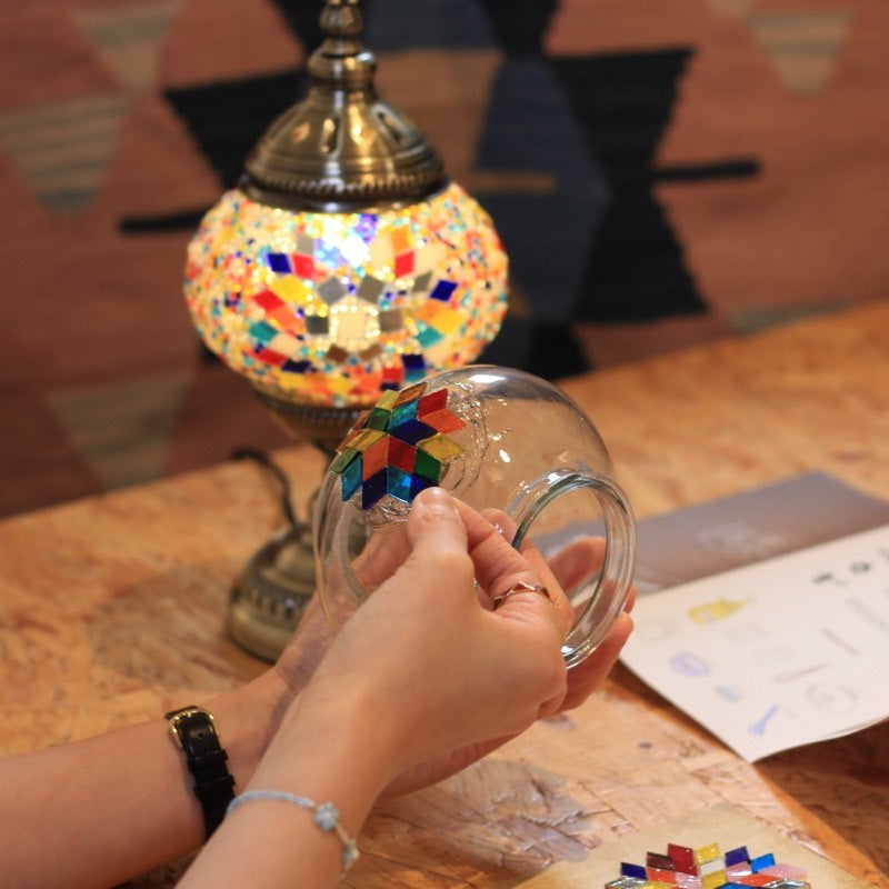A colorful mosaic lamp glowing on the table