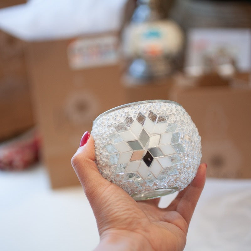 A finished mosaic globe lifted out of the kit box